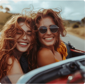 Duas mulheres jovens sorrindo em um carro conversível